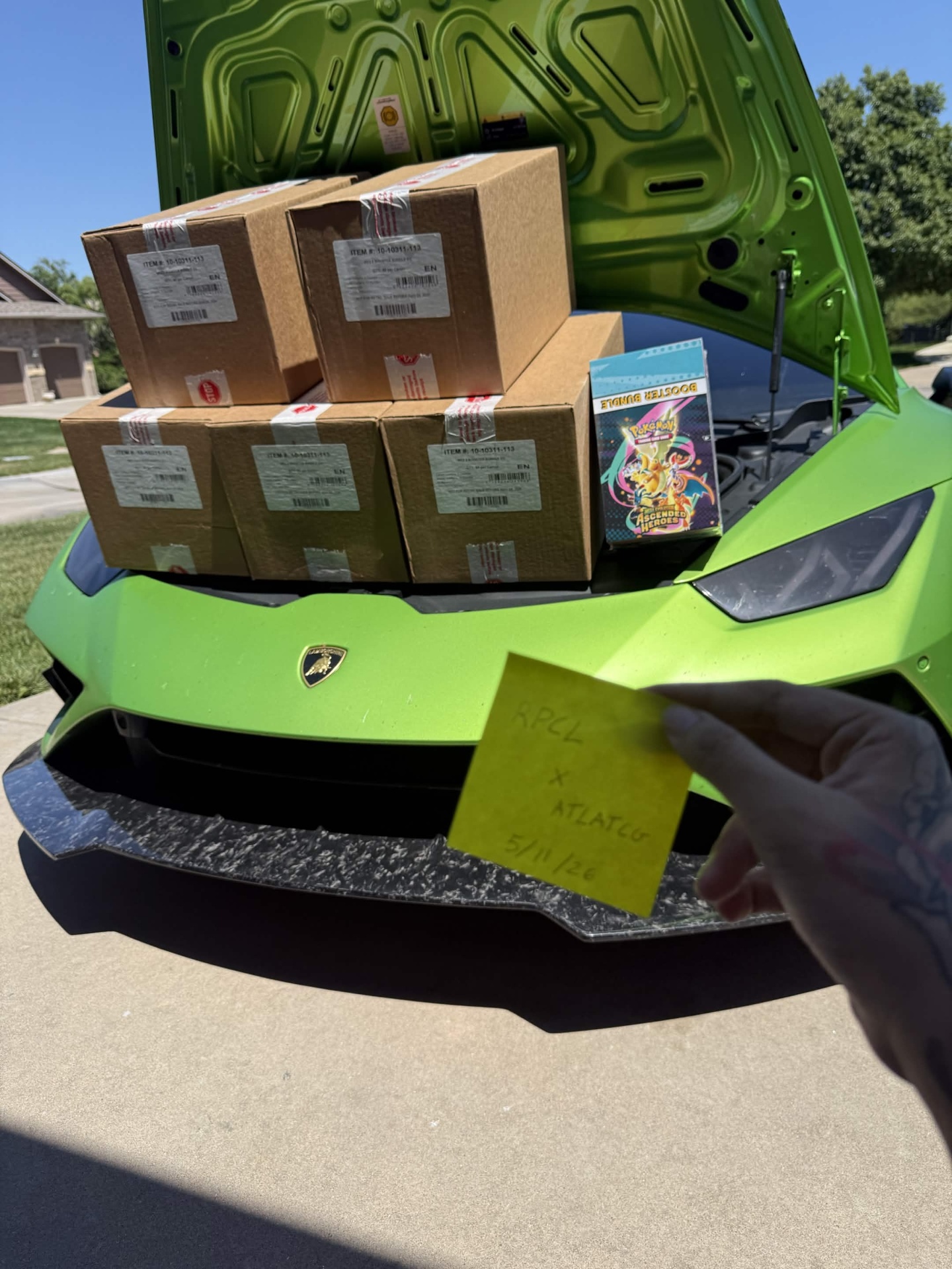 Pokemon TCG boxes loaded on Lamborghini Huracan with RPCL x ATL TCG note